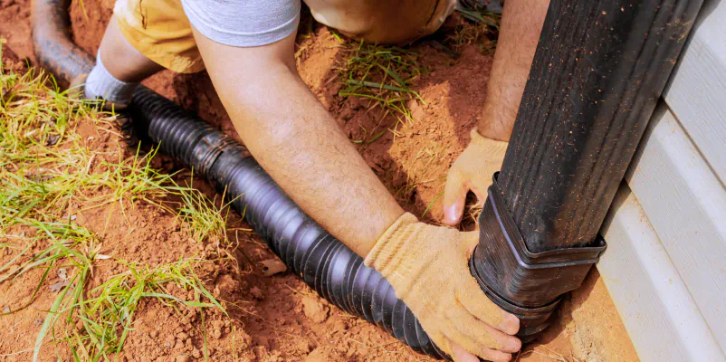 worker installing french drain